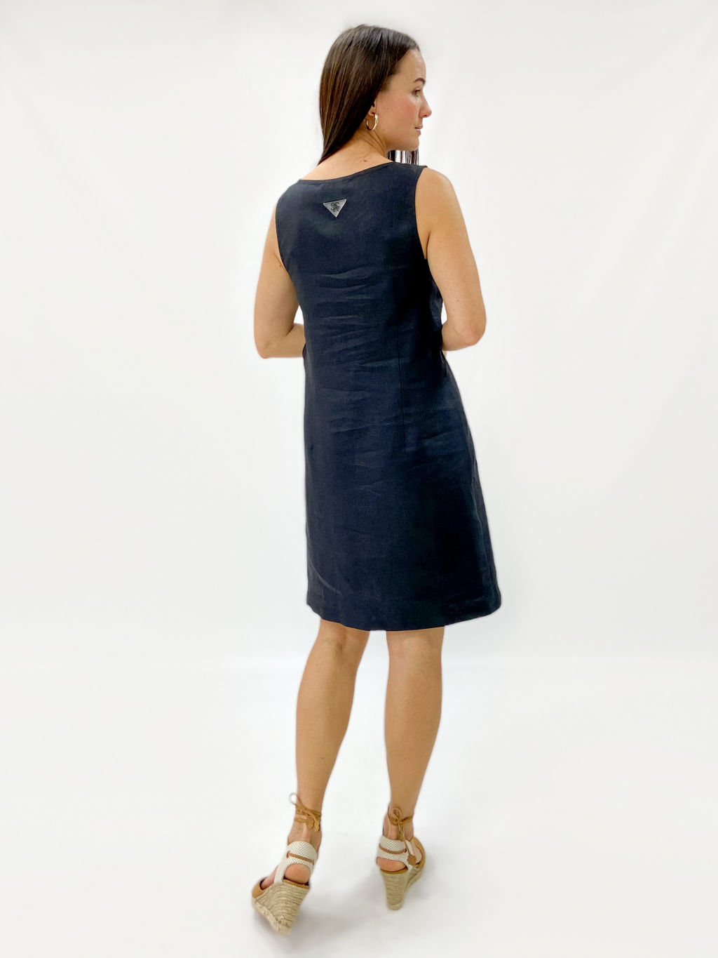 Платье силуэта трапеция, без рукавов. V-образно оформленный вырез проймы выделен широкой деталью в области груди. Длина выше колен.