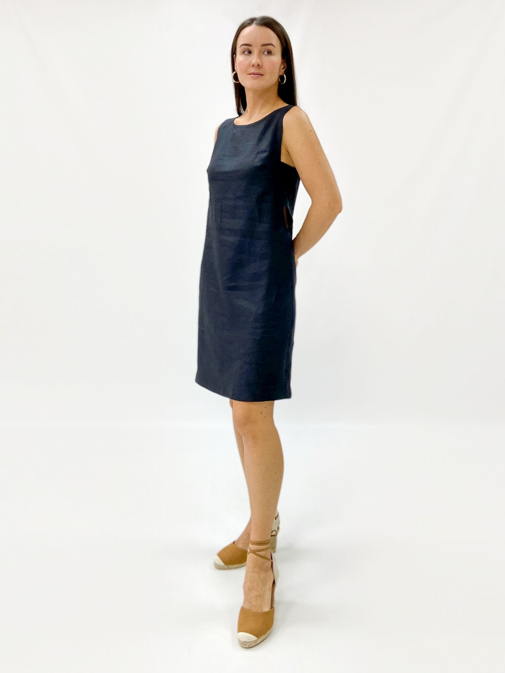 Платье силуэта трапеция, без рукавов. V-образно оформленный вырез проймы выделен широкой деталью в области груди. Длина выше колен.